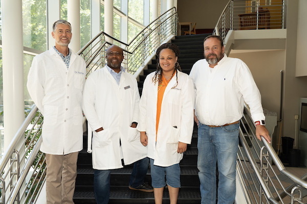 Four faculty in Parkinson Hall stairwell.